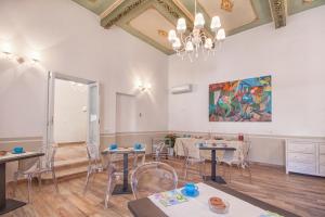 a dining room with tables and chairs and a painting at Residenza Le Zagare in Castellammare del Golfo