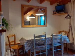 a dining room table with blue chairs and a mirror at La Maisonnette in Wissant