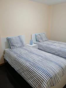 フィニステレにあるApartamentos Finisterre Atlánticoのベッドルーム1室(隣り合わせのベッド2台付)