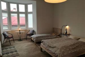 a bedroom with two beds and a table and windows at Apartament Barbara - przy rynku in Wadowice