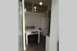 a kitchen with a white table and chairs and a white refrigerator at Apartament Barbara - przy rynku in Wadowice