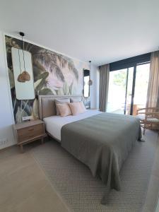 Un dormitorio con una cama grande con almohadas rosas. en RENTALMARE, en Denia