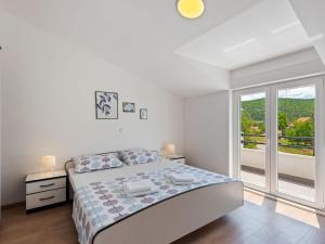 Habitación blanca con cama y balcón. en Bonaventura Countryside Villa near Split, en Neorić