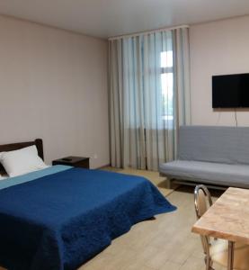 a bedroom with a blue bed and a couch at Apart Hotel Smart Studio in Kharkiv