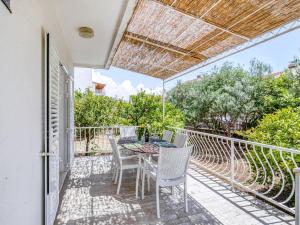 patio ze stołem i krzesłami na balkonie w obiekcie Villa in Orebi with Garden near Seabeach w Orebiciu