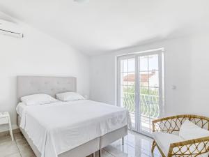 Biała sypialnia z łóżkiem i balkonem w obiekcie Villa in Orebi with Garden near Seabeach w Orebiciu