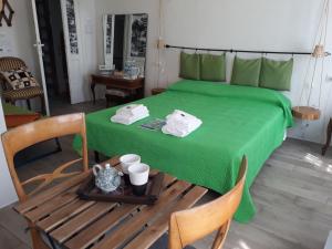 a room with a green bed with a table and a chair at Come una volta in Monte Isola