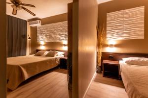 Cette chambre comprend deux lits et un ventilateur de plafond. dans l'établissement Villa Maimare, à Biograd na Moru
