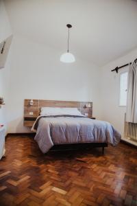 um quarto com uma cama e piso em madeira em Casa Compartida Barranca Yaco - Habit privadas em Córdoba