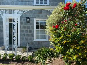a house with a window and a bush with red roses at Coswarth House in Padstow