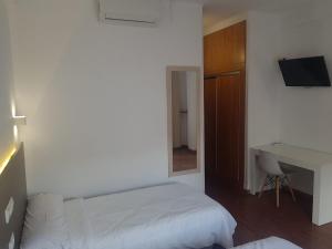 a white bedroom with a bed and a desk at Hotel Torremolinos Centro in Torremolinos