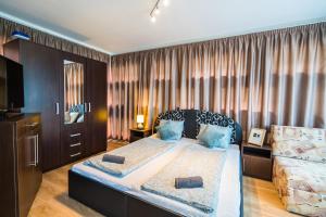 ein Schlafzimmer mit einem großen Bett in einem Zimmer in der Unterkunft Siesta Sziget - Balaton-parti Apartmanok in Siófok