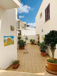 a courtyard with potted plants on the side of a building at Vivaldi Appartamenti in Marinella di Selinunte