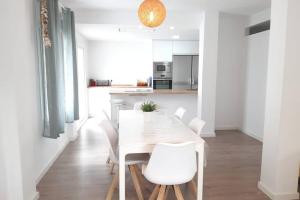 a white dining room with a white table and white chairs at CASA DE DISEÑO EN LA PLAYA. in Rota