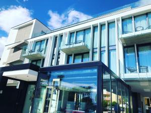 an office building with glass windows on the side of it at MaisonMe Boutique Hotel in Bardolino