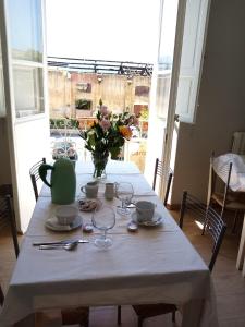 un tavolo bianco con un vaso di fiori sopra di BINARIO 5 a Lucca