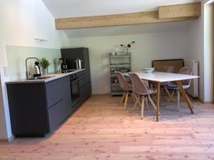 a kitchen with a table and chairs and a refrigerator at Seehof Apartments in Walchensee