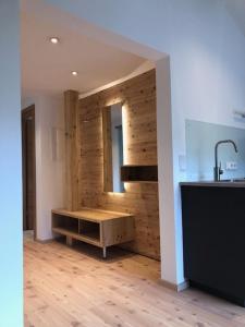 a bathroom with a wooden floor and white walls at Seehof Apartments in Walchensee