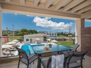 a patio with a table and chairs and a pool at Mystique Luxury Suites & Maisonettes in Laganas