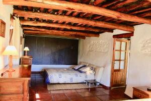 a bedroom with a bed and a wooden ceiling at Cortijo Close in Busquístar
