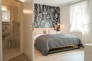 a bedroom with a bed with a black and white wallpaper at Hotel & Restaurant Am Alten Rhin in Neuruppin