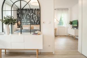a living room with a mirror and a white dresser at Hotel & Restaurant Am Alten Rhin in Neuruppin