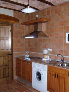 a kitchen with a washing machine and a sink at Apartamentos Rurales La Oropendola in Jaraiz de la Vera