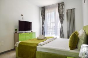 ein Schlafzimmer mit einem großen Bett und einem TV darauf in der Unterkunft Green Apartment Spa n Pool Beach Resort in Mamaia Nord – Năvodari