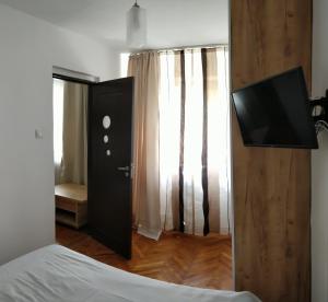 コンスタンツァにあるConstanta City Apartmentのベッドルーム(ベッド1台、薄型テレビ付)