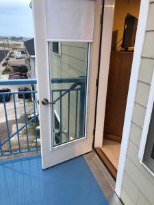 a door to a balcony with a view of a street at Misquamicut Beach Front Inn in Misquamicut