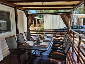 a table and chairs sitting on a porch with a table and chairs at Mobile home Laurus Soline in Biograd na Moru