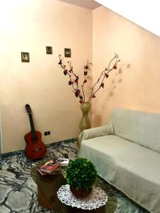 ein Wohnzimmer mit einem Sofa und einer Gitarre in der Unterkunft Regina di denari in Pachino