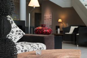 a red vase sitting on a table in a living room at Golden Residence Hotel in Funchal