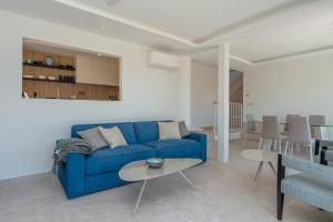 卡萊利亞德帕拉弗魯赫爾的住宿－L-3 CALELLA DE PALAFRUGELL 5/ 6 PAX，客厅配有蓝色的沙发和桌子