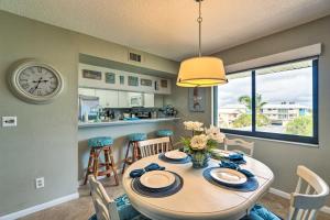 a dining room with a table and a clock on the wall at Anna Maria Island Resort Condo with Prime Location! in Bradenton Beach