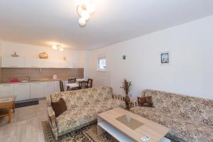 a living room with two couches and a table at City View Apartment in Mostar