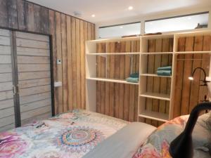 um quarto com uma cama e paredes de madeira em 't Grüne Huysje em Otterlo