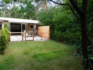 a backyard with a deck and a house at 't Grüne Huysje in Otterlo