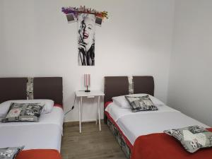 two beds in a room with a cross on the wall at Apartmani Pilić Ljiljana in Brodarica +40 photos