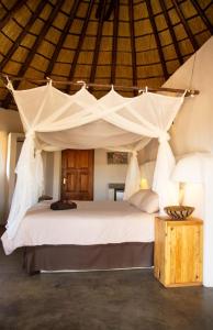 a bedroom with a large white bed with a canopy at Lamai Safari Lodge in Balule Game Reserve