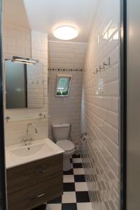 ein Badezimmer mit einem Waschbecken, einem WC und einem Spiegel in der Unterkunft Iglo Bungalow 26 in Chaam