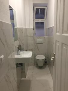 a white bathroom with a sink and a toilet at Gästehaus Jasmin in Lindau