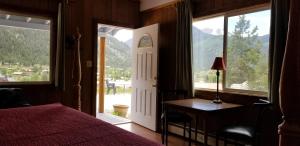 a bedroom with a bed and a table and a window at Alpine Moose Lodge in Lake City