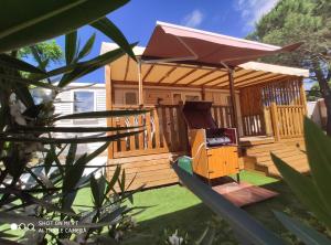 a wooden cabin with a grill in the yard at MAR ESTANG in Canet-en-Roussillon