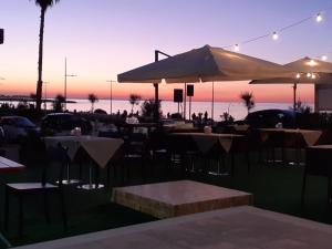 a restaurant with tables and umbrellas in front of the ocean at Bari Lory’s Home in Bari