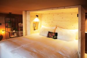 Schlafzimmer mit einem großen weißen Bett mit einem Kopfteil aus Holz in der Unterkunft ANNAS STUBE - Boutique Design Bauernhof in Waldkirch