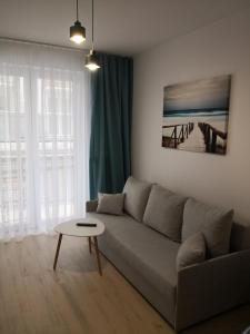 - un salon avec un canapé et une table dans l'établissement Apartament LUCKY, à Świnoujście