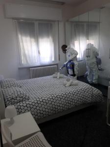 une chambre avec 2 personnes debout à côté d'un lit dans l'établissement Ciro BED AND BREAKFAST la villetta, à Pioltello