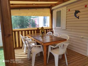 a wooden table and chairs on the porch of a house at MAR ESTANG in Canet-en-Roussillon