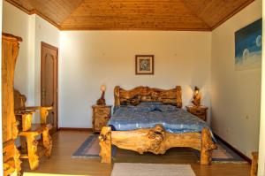 a bedroom with a large wooden bed in a room at Rancho Mar à Vista in Atalaia de Cima